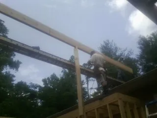 Carpenter setting a ridge beam over a new addition frame — Ice Dam Removal by Roofing Brothers in High Bridge