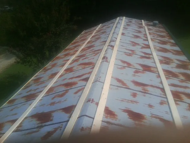 Rusted metal roof panels with new wood purlins before replacement — Storm Damage Roof Repair in High Bridge by Roofing Brothers