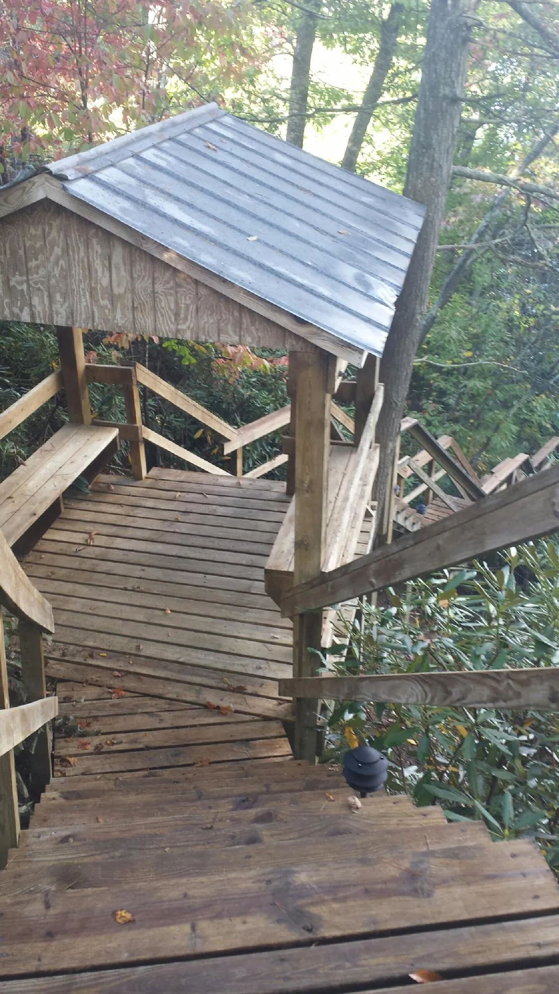 Metal roofed shelter over wooden steps on a wooded walkway — Skylight Repair & Installation work by our crew in High Bridge